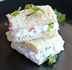 two sandwiches stacked on top of each other with toppings and garnishes