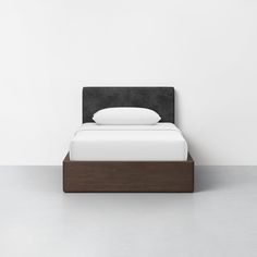 a bed with a wooden frame and white sheets