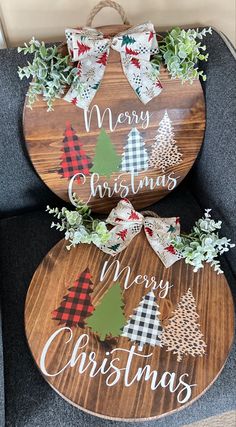 two wooden christmas signs sitting on top of a chair