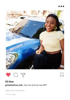 a woman sitting in front of a blue car wearing large hoop earrings and a yellow t - shirt