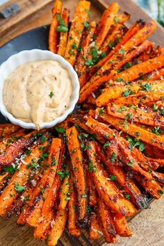 grilled carrots on a platter with dip and parsley garnish