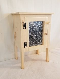 a small wooden table with a black and white design on the front door, sitting against a white background