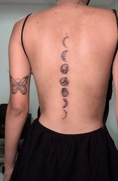 the back of a woman's body with tattoos on her upper and lower back