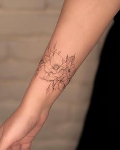 a woman's arm with a flower tattoo on it