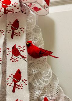 two red birds sitting on top of a white ribbon