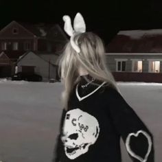 a girl with bunny ears is walking in the snow