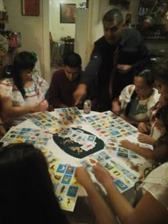 a group of people sitting around a table playing a board game with cards on it