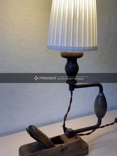 a lamp that is sitting on top of a table next to a box with an object in it