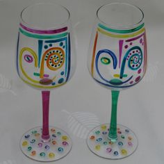 two hand painted wine glasses sitting next to each other