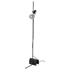 a black floor lamp with a white light on it's side and an extension cord