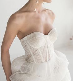 a woman wearing a white dress with ruffles on it