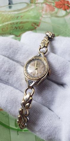 This is a rare, very pretty, Art Deco white and yellow gold filled 1937's, with 2 diamonds, Bulova women's mechanical watch. What a special piece of jewelry! There is a white gold and diamonds slightly extended bezel set in yellow gold, with beautuful textured Art Deco design. Simply beautiful! This special, dainty watch is in wonderful vintage condition,  showing how much it was cherished and loved.  It works well. Please see photos as they speak wonderfully to the beauty and condition of this rare bracelet! What a special watch that is sure to make a great addition to any jewelry collection!  An unforgettable gift idea as well! The flex band measures approximately 6 1/2".  This watch is running well currently but the service history is unknown so cannot guarantee how long it will run bef Dainty Gold Watch Vintage, Vintage Gold Watch Women’s, Watches For Women Classy, Zeppelin Watch, Bulova Watches Women, Dainty Watch, Vintage Bulova Watches, Vintage Gold Watch, Bulova Watches