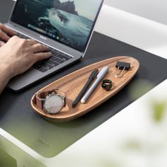 a person using a laptop on a desk with other office supplies and gadgets around it