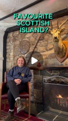 a woman sitting in a chair next to a fireplace with deer heads on the wall