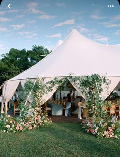 a large white tent sitting on top of a lush green field