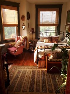 a bed room with a neatly made bed and lots of windows