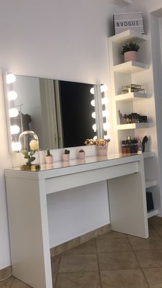 a white vanity with lights on it and a mirror in front of the counter top