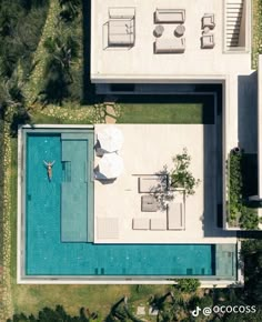 an aerial view of a house with a swimming pool and lounge chairs on the lawn