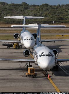 two airplanes parked on the tarmac at an airport