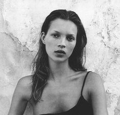 a black and white photo of a woman in a bathing suit with her hands on her hips