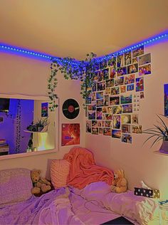 a bed room with a neatly made bed and lots of pictures on the wall above it