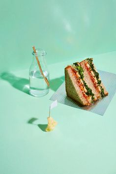 a piece of cake sitting on top of a table next to a glass vase with water