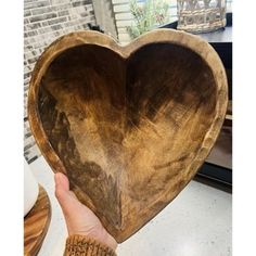 a wooden heart shaped bowl sitting on top of a table