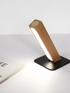 a desk lamp sitting on top of a table next to a book