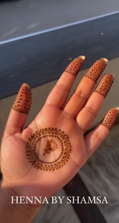 henna by shamsa on the palm of a woman's hand with an intricate design