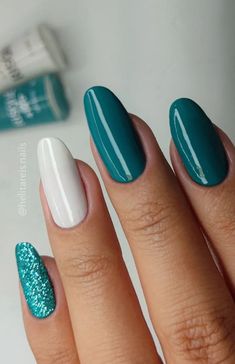 a woman's hand with blue and white nail polish