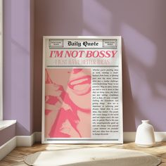 a magazine cover sitting on top of a wooden floor next to a vase and window