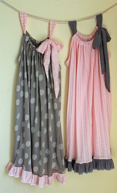 two dresses hanging up against a wall with polka dots on the bottom and one in pink, grey and white