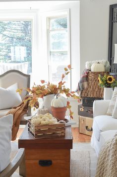 a living room filled with furniture and lots of fall decor on top of it's coffee table