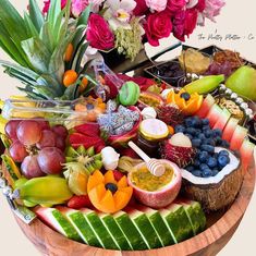 a wooden bowl filled with lots of different types of fruits and vegtables