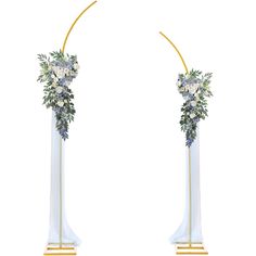 two tall white and gold floral arrangements on top of each other, with one flower arrangement in the middle