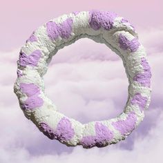 there is a circular purple and white object in the clouds