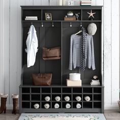 a coat rack filled with lots of clothes next to a rug and shoes on top of a wooden floor