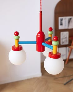 two red, yellow and green lights hanging from a chandelier in a living room