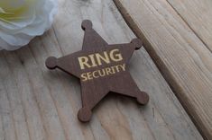 a wooden ring security badge next to a white rose