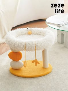 a cat bed that is on the floor in front of a white table and chair