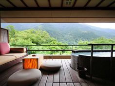 a hot tub sitting on top of a wooden deck next to a large open window