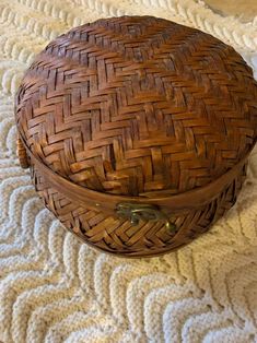 an old wooden basket sitting on top of a white blanket