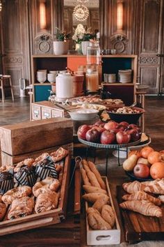 an assortment of breads, pastries and fruit on display in a hotel lobby