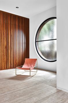 a chair sitting in front of a round window