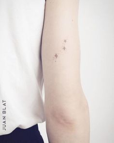 a woman's arm with small stars on the back of her left arm, in black and white