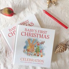 two baby's first christmas books are sitting on a bed next to other items