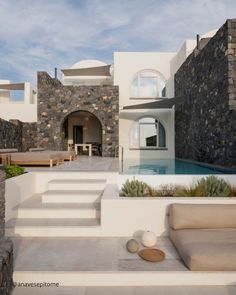 a house with stone walls and steps leading up to the pool