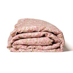 the pink flowered blanket is folded on top of it's pillowcases