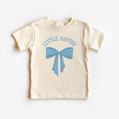 This cute toddler Coquette little sister shirt is 100% cotton, has a tear away tag for your toddler's comfort and comes in 3 Bella Canvas colors. In sizes 2T-5T, choose Black, White or Natural to make this Little Sister Bow announcement shirt the sweetest sister shirt! Don't see your size? Message me! I love custom orders. DETAILS .100% Cotton .Bella Canvas tee .Tear away label .Runs true to size .Props in any photos are not included and are for styling purposes only .Colors may slightly vary from styled photos  SIZING This graphic tee design will be printed on a Bella Canvas shirt that is high quality, comfortable and so soft! Sizing runs true to size (please refer to the size chart for exact measurements). If you'd like a more oversized look I would recommend ordering a size up. If you p Cute Cotton T-shirt For Birthday, Unisex Cute Short Sleeve Shirt, Cute Cotton Shirt With Name Print, Cute Cotton Shirt As Gift, Cute Cotton Tops For Birthday, Unisex Cute Cotton Shirt, Blue Cotton Top As A Gift, Blue Cotton Tops As A Gift, Blue Cotton Tops For Gifts