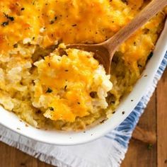 a casserole dish filled with mashed potatoes and topped with a wooden spoon